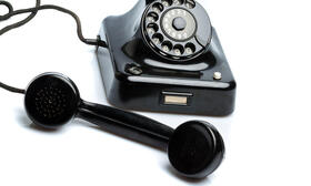 The picture shows an old telephone with dial disc